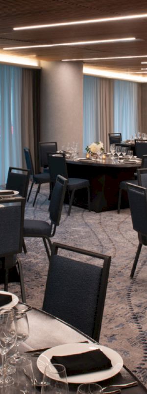 This image shows an elegant banquet hall with round tables, neatly arranged chairs, and set tables ready for an event or dinner.